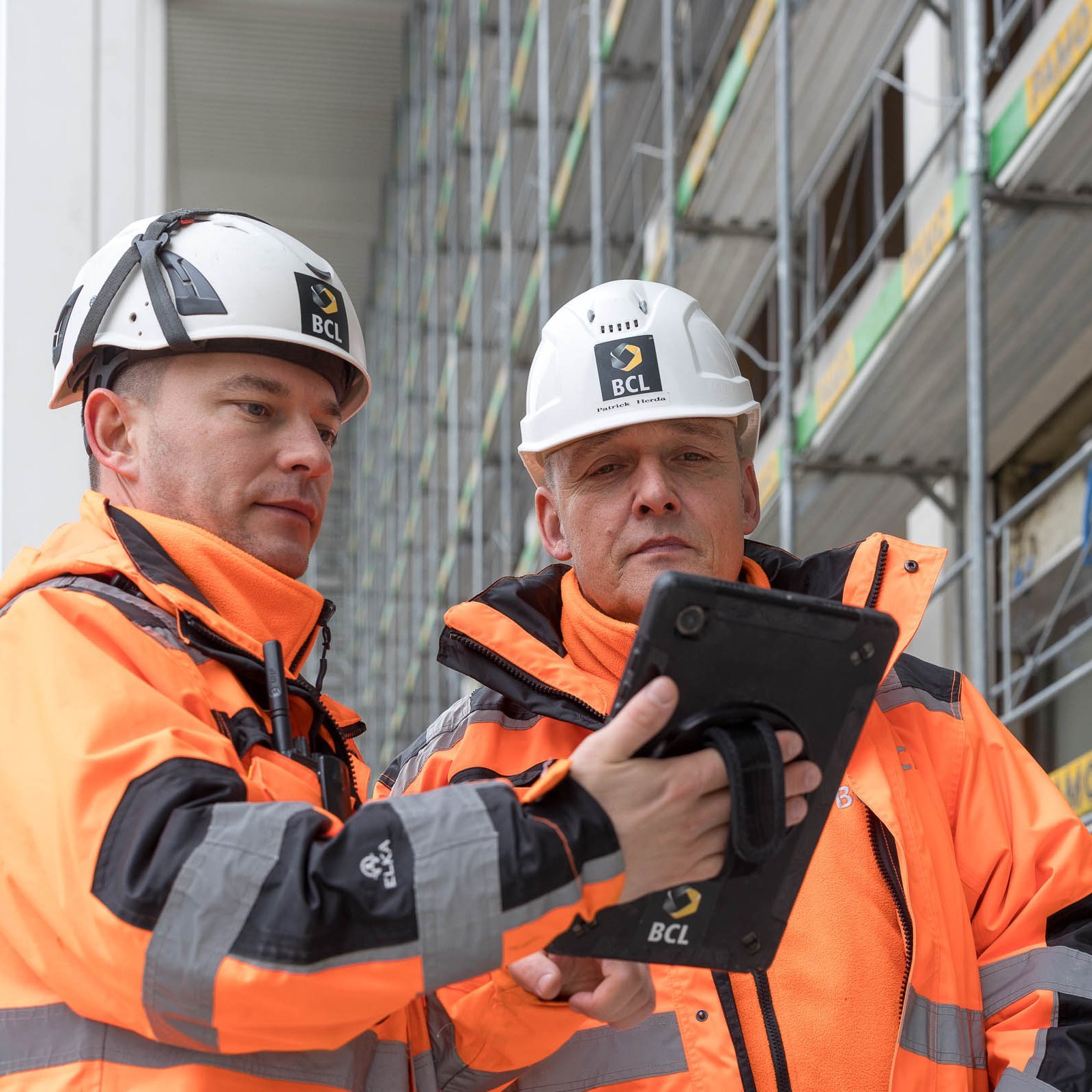 Zwei BCL Mitarbeitende auf der Baustelle mit Tablet