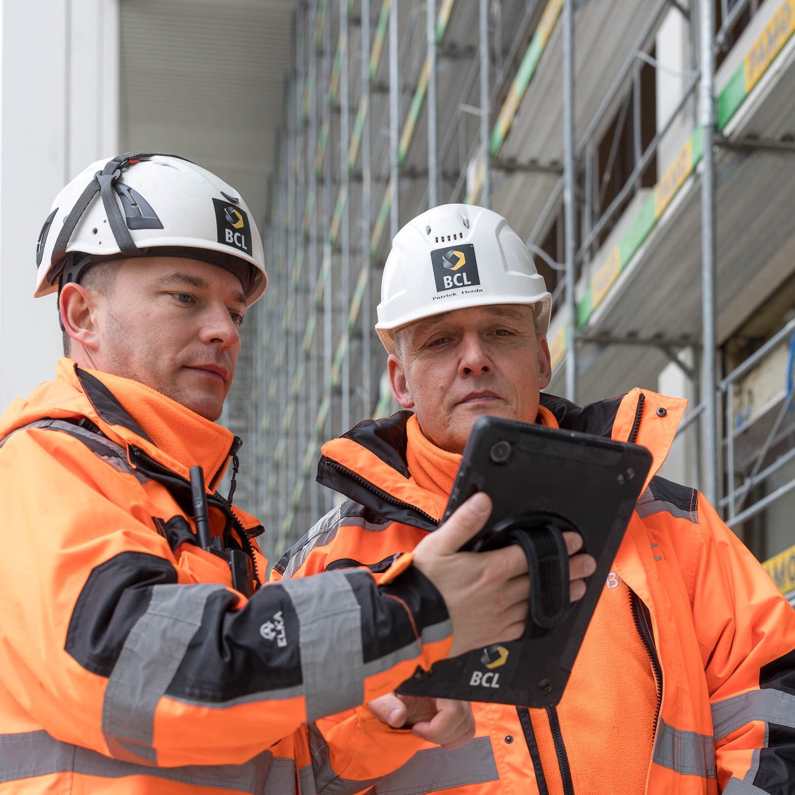 Two BCL employees on a construction site with a tablet